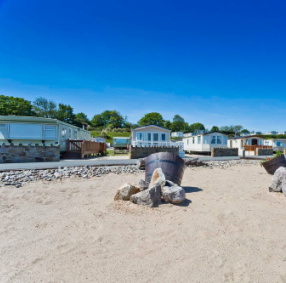 Beach location at The Beach Caravan Park with caravans in background